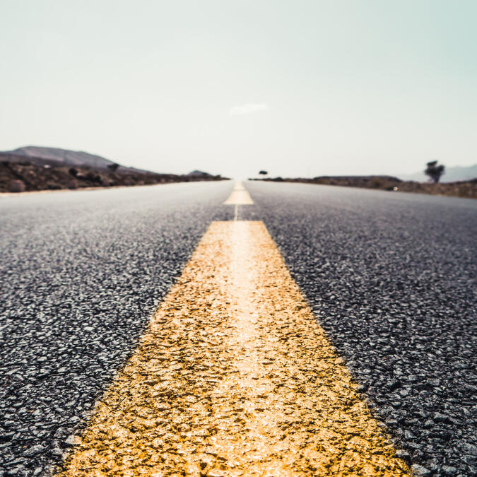 A desert highway, photo taken from the ground on yellow center line